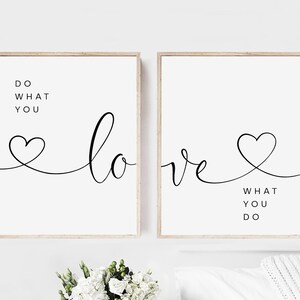 May include: Two framed art prints with a minimalist design. Each print features the words "Do What You Love" and "Love What You Do" in black script and a heart symbol on a white background. The frames are a light wood color.