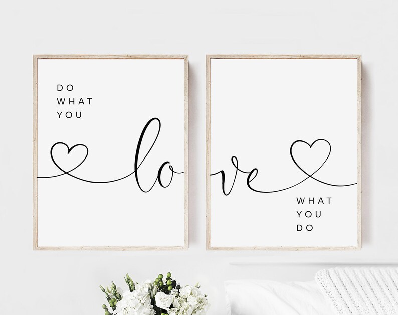 May include: Two framed art prints with a minimalist design. Each print features the words "Do What You Love" and "Love What You Do" in black script and a heart symbol on a white background. The frames are a light wood color.