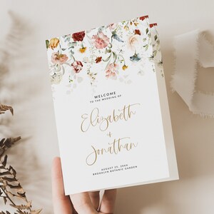 Puede incluir: Un programa de boda blanco con un diseño floral de acuarela en tonos rojos, rosas y azules. El texto dice "Bienvenido a la boda de Elizabeth & Jonathan 25 de agosto de 20XX Jardín Botánico de Brooklyn".