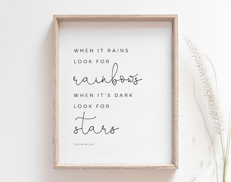 May include: A framed print with a white background and black text that reads "When it rains look for rainbows. When it's dark look for stars. Oscar Wilde."