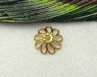May include: Gold-toned metal flower charm with a circular center hole. The charm is on a white background.