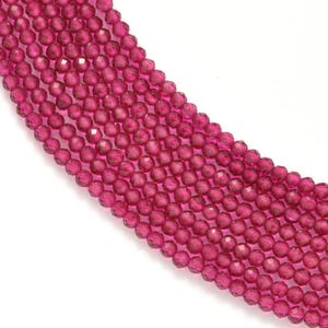 Puede incluir: Una hebra de cuentas de cristal facetadas de color rosa. Las cuentas son redondas y tienen un acabado brillante.