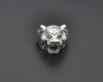 May include: A silver ring featuring a detailed tiger head design. The tiger's mouth is open and its eyes are visible.