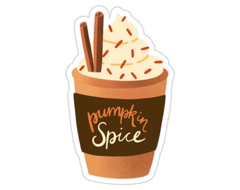 Op de afbeelding: Een bruine papieren beker met een witte slagroomtopping en rode sprinkles. De beker heeft een bruine papieren hoes met de tekst "pumpkin spice" in zwart.