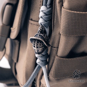 Paracord setup image with bead in action on survival-style braided lanyard.