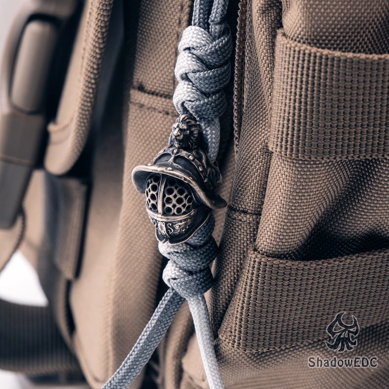 Paracord setup image with bead in action on survival-style braided lanyard.