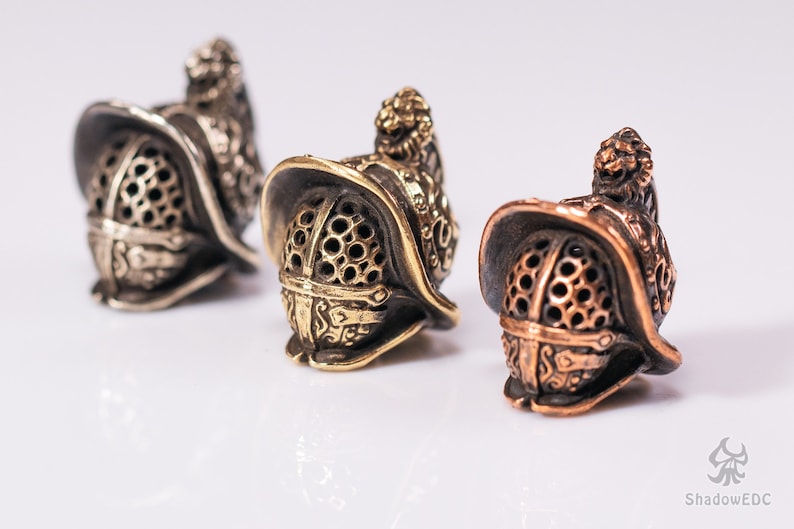 three Gladiator Helmet beads in brass, copper, and white brass finishes.