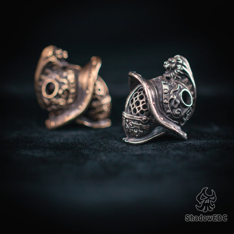 Side view of Gladiator bead showcasing engraved scrollwork and crest detail.