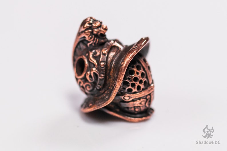 Red copper version of helmet bead highlighting sculptural depth and detail.