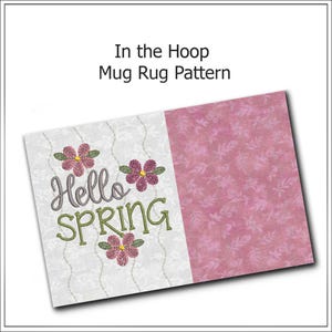 May include: A rectangular mug rug pattern with the text "Hello SPRING" embroidered in green and gray, accompanied by pink floral designs. The rug has a white patterned section and a pink floral patterned section. The text "In the Hoop Mug Rug Pattern" is at the top.