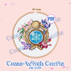 May include: A cross stitch pattern featuring a circular design with a blue and white snowflake inside a gold frame. The frame is surrounded by pink, purple, and green flowers. The pattern is available as a PDF download.