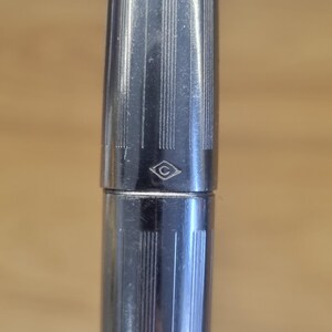 Puede incluir: Una taza de cer&aacute;mica blanca con un asa negra y el texto "But First, Coffee" en negro, en negrita. La taza est&aacute; sobre una superficie blanca.