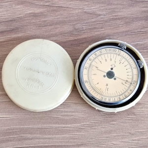 Puede incluir: Un juego de tres tazas de cerámica con un acabado gris moteado. Cada taza presenta un diseño pintado a mano diferente: una cordillera, un sol y una luna creciente. Las tazas tienen una estética minimalista y moderna.