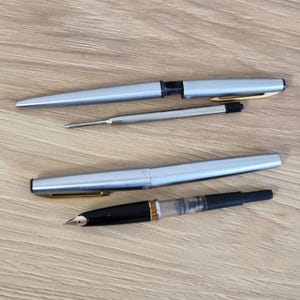 Może przedstawiać: Rustykalny drewniany znak z napisem "Welcome to our home" w białych literach. Znak ma postarzaną powierzchnię i prosty, zachęcający design, idealny do dekoracji wejścia.