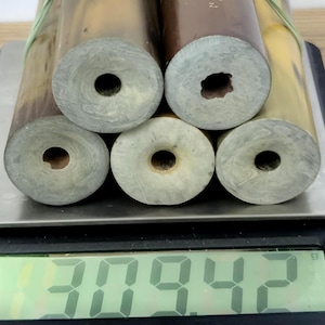 Könnte beinhalten: Fünf zylindrische Röhren mit glatten, hellgrauen Enden und hohlen Mitten, die in einem Bündel angeordnet sind. Die Röhren weisen entlang ihrer Länge verschiedene Braun- und Beigetöne auf. Eine digitale Waage zeigt das Gewicht von 309,42 Gramm an.