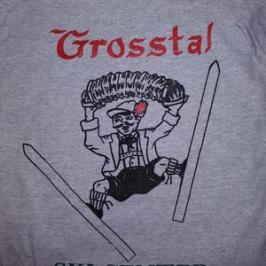 May include: Gray t-shirt with a red graphic of the words "Grossstal Ski Center Allegany, N.Y.". The graphic also includes a cartoon skier holding a pair of skis.