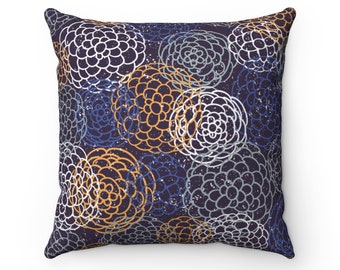 May include: A square throw pillow with a navy blue background and a pattern of white, orange, and blue floral designs.