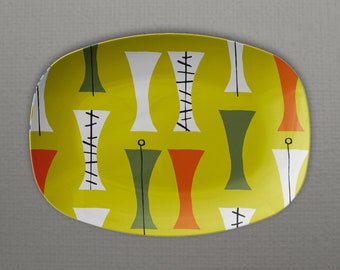 May include: A yellow oval serving dish with a geometric pattern in shades of green, orange, white, and black.
