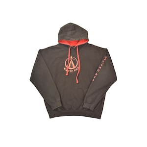 May include: A dark brown hooded sweatshirt with a red interior. The front of the sweatshirt features a graphic of a burning tent with the text "Wicker Man" around it. The right sleeve has a repeating pattern of runes in red.