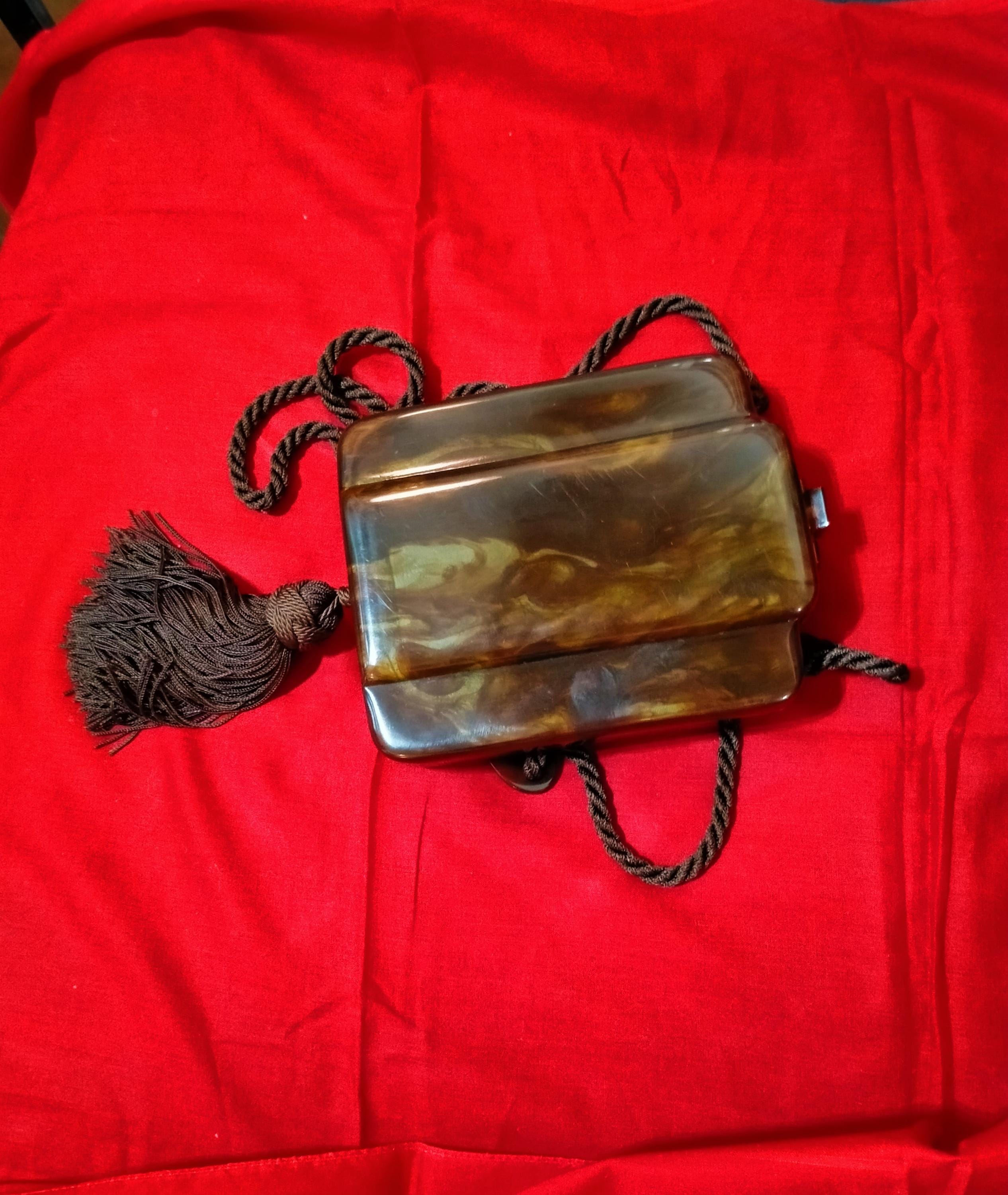 Vintage 1960s-70s Fendi clutch bag in tortoiseshell lucite with cord shoulder strap and decorative silk tassel.