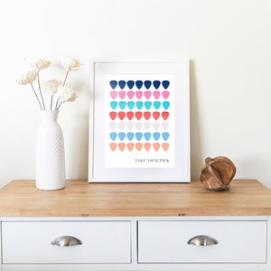 May include: A white framed print featuring a colourful pattern of guitar picks in shades of blue, pink, red and orange. The text "Take Your Pick" is printed at the bottom of the print.