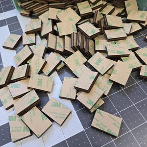 May include: A large pile of brown and green adhesive squares with the 3M logo printed on them.