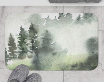 May include: A watercolor-style bath mat with a misty forest scene in shades of green and gray. The mat features a soft, textured surface and is perfect for adding a touch of nature to your bathroom.