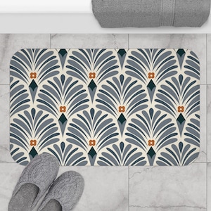 Peut inclure: Un tapis de bain bleu et blanc avec un motif géométrique de formes de ventilateur stylisées et de fleurs orange.