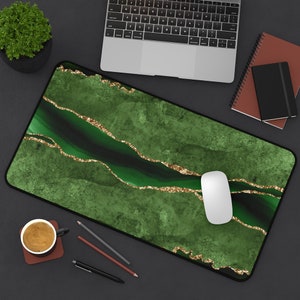 May include: Green and gold marble-patterned desk mat with a white computer mouse on top. The mat has a dark green background with gold glitter accents.