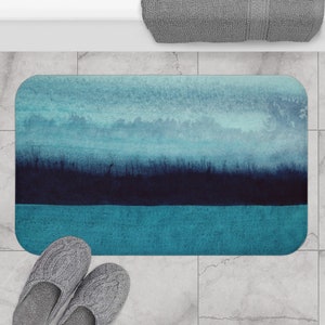 Könnte beinhalten: Eine blaue und türkisfarbene Badematte mit einem verblassten, abstrakten Design. Die Matte hat eine strukturierte Oberfläche und ist perfekt, um Ihrem Badezimmer einen Hauch von Farbe zu verleihen.