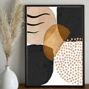 May include: Abstract art print in a dark wood frame. The artwork features black, tan, and gold shapes with a white background. The design includes organic shapes and dotted patterns, creating a modern aesthetic.