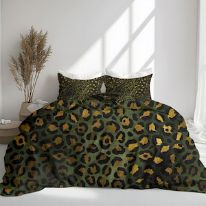 May include: A bed set featuring a green and black leopard print with gold accents. The set includes a comforter and two pillowcases. The bedding is displayed on a white bed with a neutral background.