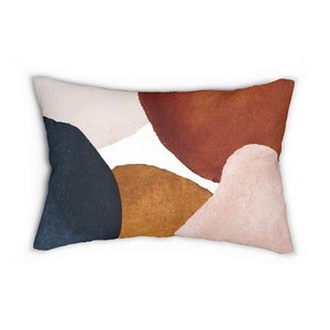 Op de afbeelding: Rechthoekig decoratief kussen met een abstract ontwerp. Het kussen heeft een witte achtergrond met overlappende vormen in marine, bruin, roest, beige en blush roze. Ideaal voor interieurdecoratie.