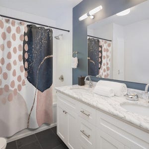a modern bathroom with a white vanity, a large mirror, and a shower curtain with a colorful abstract design.