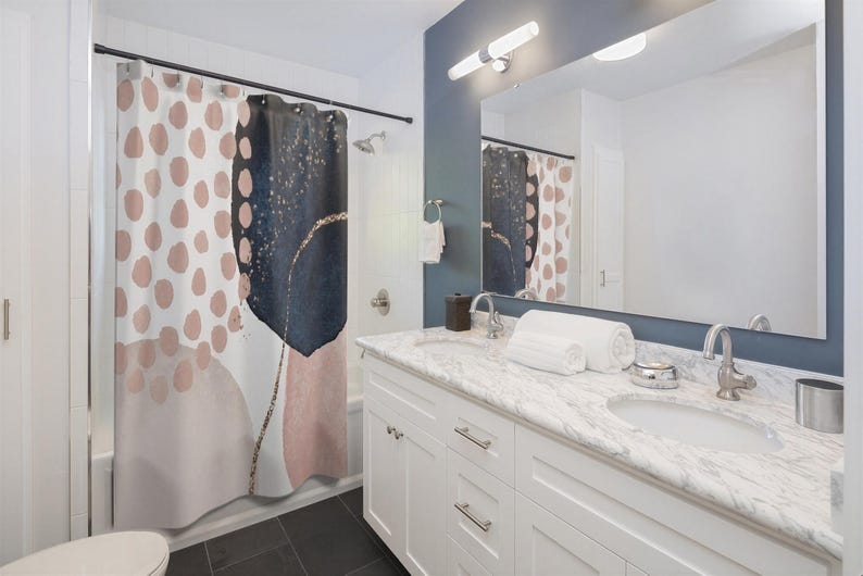 a modern bathroom with a white vanity, a large mirror, and a shower curtain with a colorful abstract design.