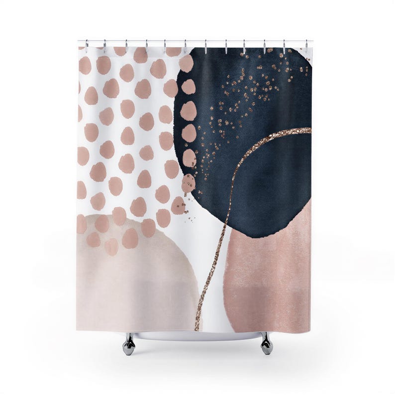 a shower curtain with a bold abstract design. The design consists of a mix of black, navy blue, and pink colors, with gold glitter accents. The shower curtain is hanging from a rod, and it appears to be a modern and stylish design.