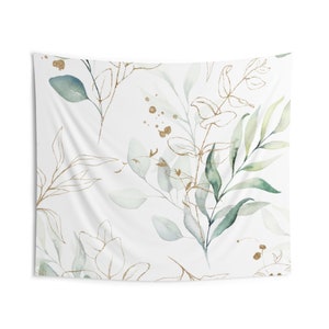 May include: A white tapestry with a green and gold floral pattern. The pattern features leaves and branches with gold accents.