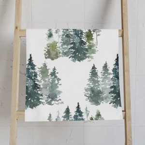 May include: A white fabric with a repeating pattern of watercolour green trees. The trees are in various shades of green and are arranged in a random pattern.