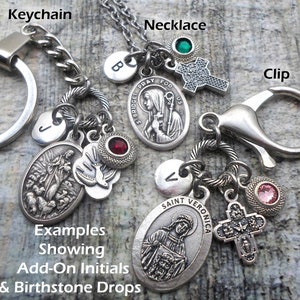 Pu&ograve; includere: Esempi di una collana e un portachiavi d'argento con vari ciondoli, tra cui una croce d'argento, un ovale d'argento con l'immagine di un santo e gocce di pietre di nascita. I ciondoli sono attaccati a una catena d'argento e a un portachiavi d'argento. Il testo "PRAY FOR US" e "SAINT VERONICA" &egrave; visibile sui ciondoli.