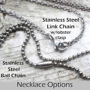 Pu&ograve; includere: Due catene d'argento, una catena a pallini e l'altra a maglie, con un moschettone. Il testo "Stainless Steel Ball Chain" e "Stainless Steel Link Chain w/lobster clasp" &egrave; visibile. Il testo "Necklace Options" &egrave; anche visibile.