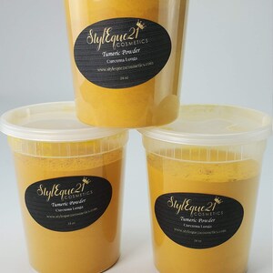 May include: Three white plastic containers filled with yellow turmeric powder. Each container has a black label with the text "Styleque 21 Cosmetics" and "Turmeric Powder Curcuma Longa" along with a website address and the size "16 oz".