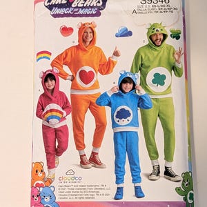 May include: A Simplicity sewing pattern envelope S9346 for Care Bears Unlock the Magic hooded loungewear sets. The package displays four variations of long-sleeve hooded tops and pants in pink, orange, blue, and green, each featuring a character emblem.