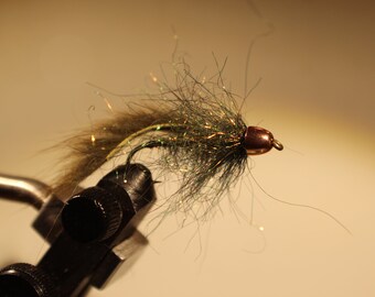 May include: A green and brown fly fishing lure with a copper bead head.