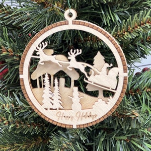 This is a round wooden Christmas ornament with a winter scene with a living hinge. It’s Santa on his midnight run.