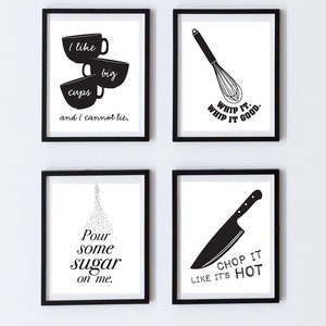 May include: Four black and white framed prints with kitchen-themed sayings. The first print says "I like big cups and I cannot lie." The second print says "Whip it. Whip it good." The third print says "Pour some sugar on me." The fourth print says "Chop it like it's hot."