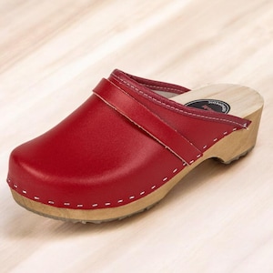 May include: Red leather clog with a wooden sole and a strap across the top.