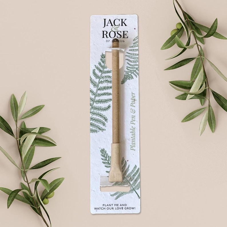May include: A plantable pen and paper set with the text "JACK ROSE 07 326". The pen is made of light brown paper and is packaged in a white card with fern illustrations. The card also includes the text "PLANT ME AND WATCH OUR LOVE GROW!"
