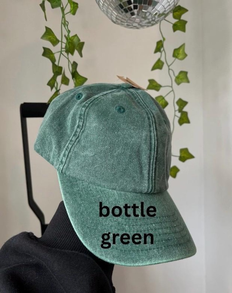 May include: A bottle green baseball cap with a curved brim. The cap is made of a soft, textured fabric.