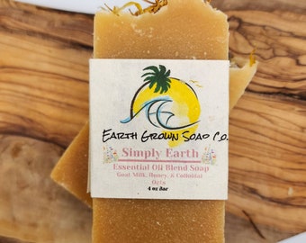 May include: A rectangular bar of soap with a light brown color and visible texture, with a paper label that reads "Earth Grown Soap Co." and "Simply Earth." The soap is 4 oz. and contains goat milk, honey, and colloidal oats.