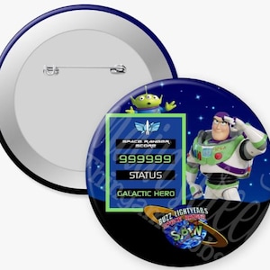 May include: A set of two round pinback buttons. One button is white with a silver pin. The other button features Buzz Lightyear, an alien, and the text "Buzz Lightyears Space Ranger Spin". The text "Space Ranger Score 999999 Status Galactic Hero" is also visible.